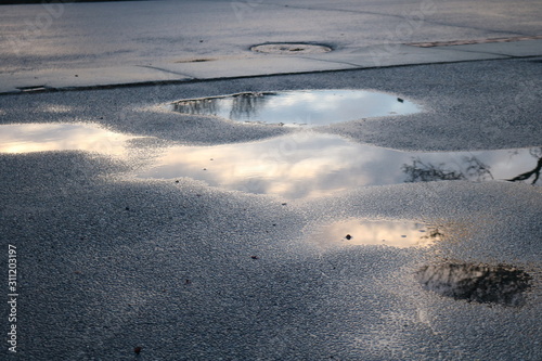 Abstract puddle cloud reflection on street pavement