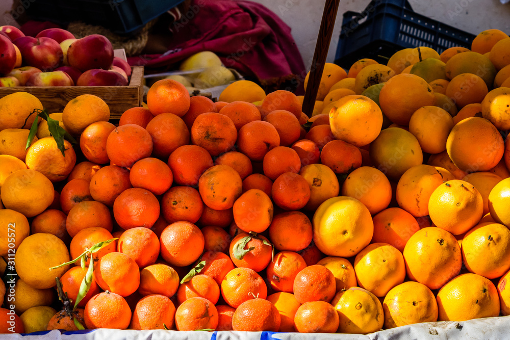 Ripe mandarins and orange fruits for sale on a fruit market