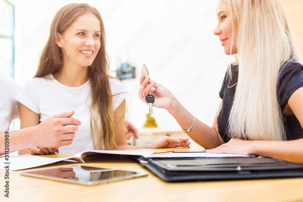 real estate agent is selling an apartment to a young family. conclusion of a lease and purchase of a house, apartment. man shows housing real estate agent is selling an apartment to a young family. conclusion of a lease and purchase of a house, apartment. man shows housing