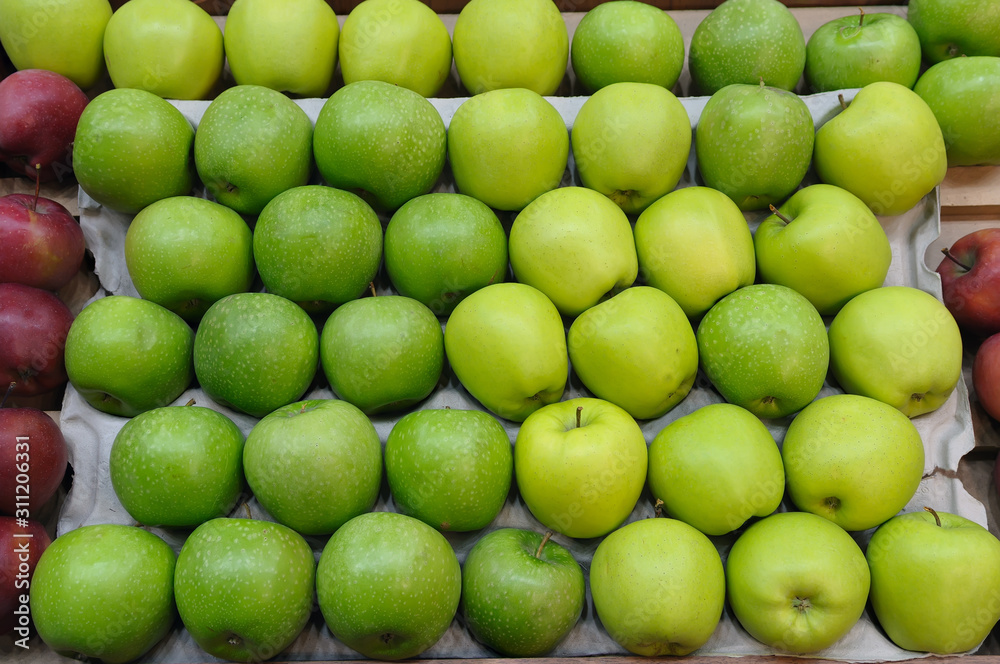 Fresh green, yellow and red apples on shelf in supermarket. Ripe apples of different types.