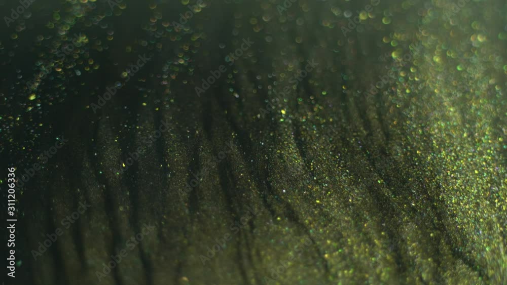 Green gold liquid glitter paint texture. Abstract dark shiny background. Macro. Motion mixed colorful ink Green gold liquid glitter paint texture. Abstract dark shiny background. Macro. Motion mixed colorful ink
