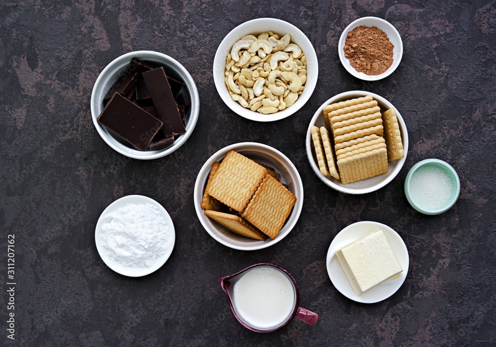 Ingredients for dessert, chocolate salami on a dark concrete background