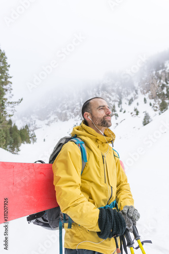 Free rider going up the mountain with his snowboard