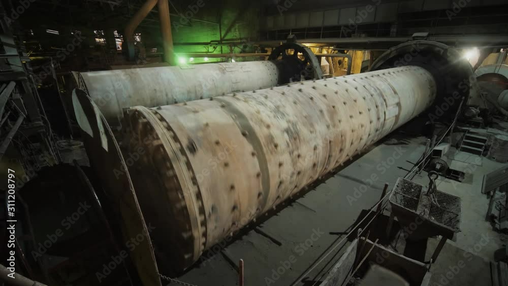 Big ball mills grinds ore on the ore-dressing factory. Rotating industrial grinders on manufacture. Big ball mills grinds ore on the ore-dressing factory. Rotating industrial grinders on manufacture.
