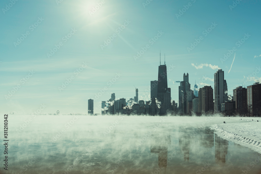 Sun above Chicago Downtown and Lake Michigan covers by fog from winter polar vortex