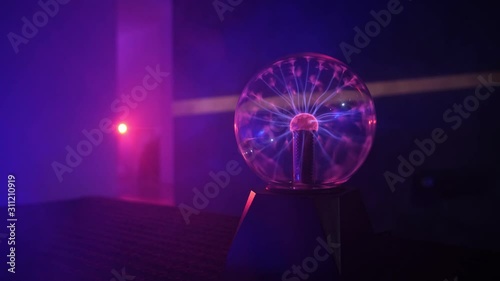 Beautiful plasma ball in the dark room make nice neon lights. photo