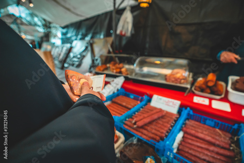 Woman with ten euro bill buying meat at a local market in the Netherlands Veere