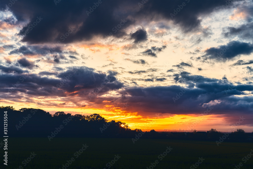 beautiful sunset over a meadow with dramatic sky