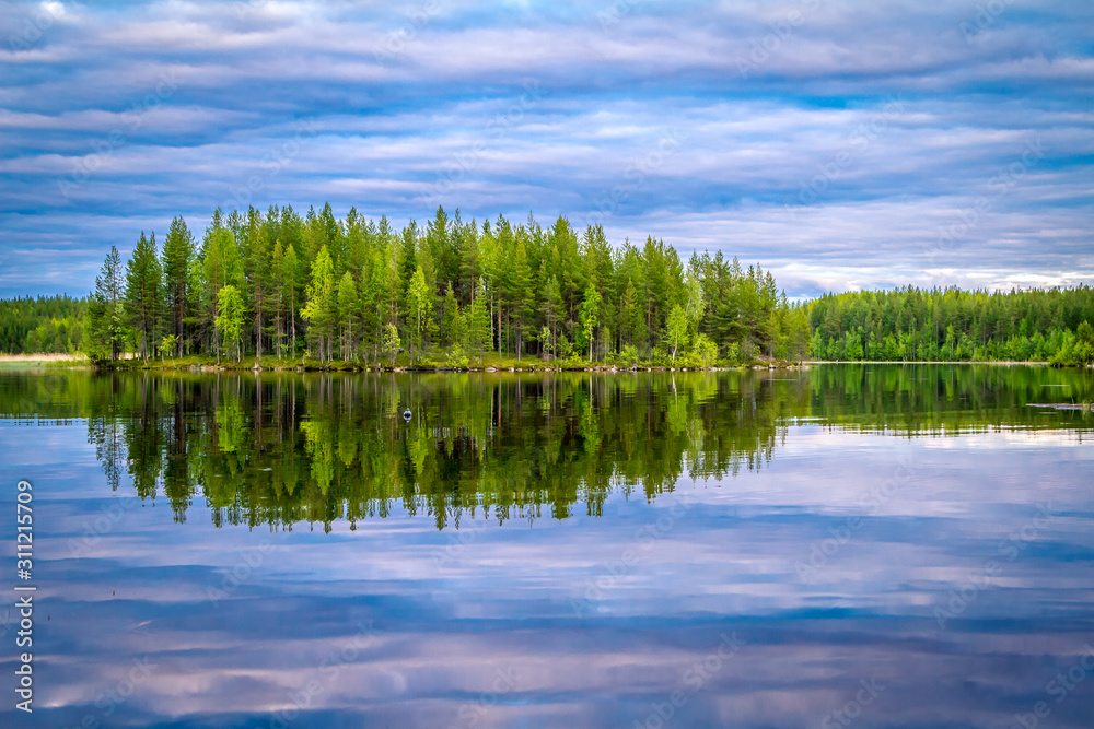 Obraz premium Karelian lakes at sunset and sunrise. Clouds and trees are reflected in the lake