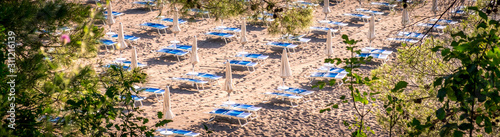 Thatched umbrellas and beach chairs on the beach. Budva, Montenegro, Balkans, Europe.