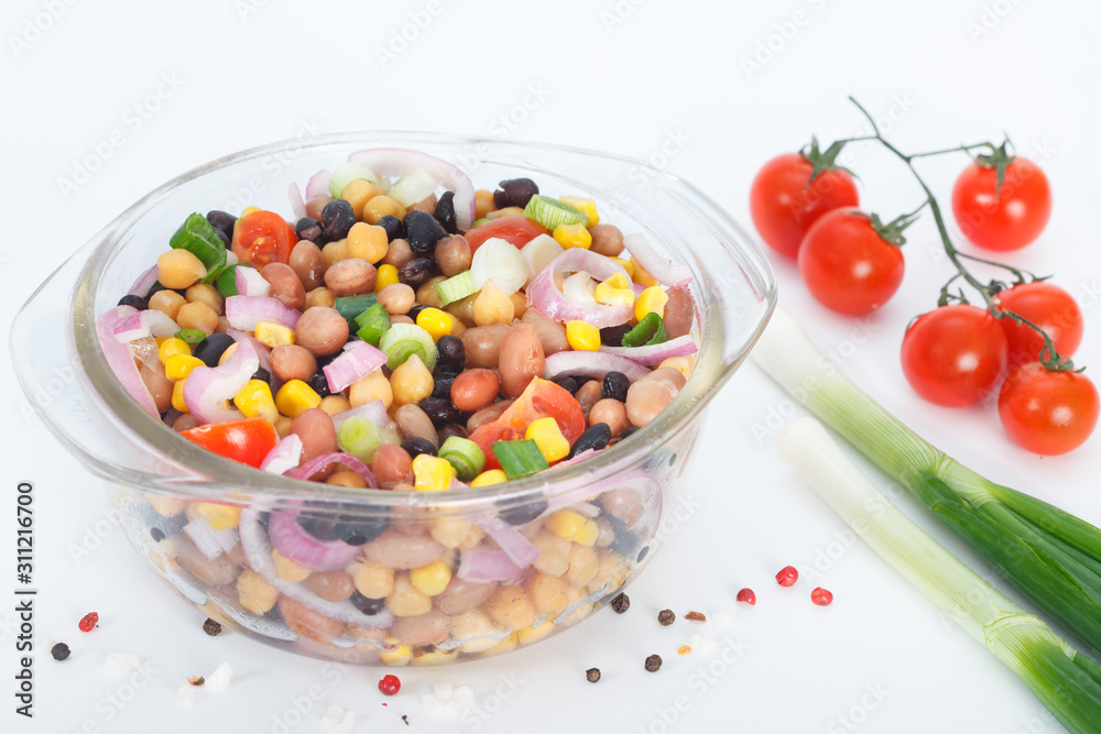 Vegetarian salad with mixed vegetables in glass bowl. Healthy vegan food with beans, cheakpeas, corn, tomato and onion. Vegetarian salad with mixed vegetables in glass bowl. Healthy vegan food with beans, cheakpeas, corn, tomato and onion.