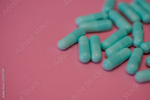 Selective focus of pills against pink background