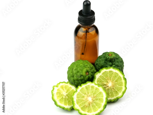 Bottles of essential oil, bergamot and sliced fruit, isolated on a white background, herbs, for health