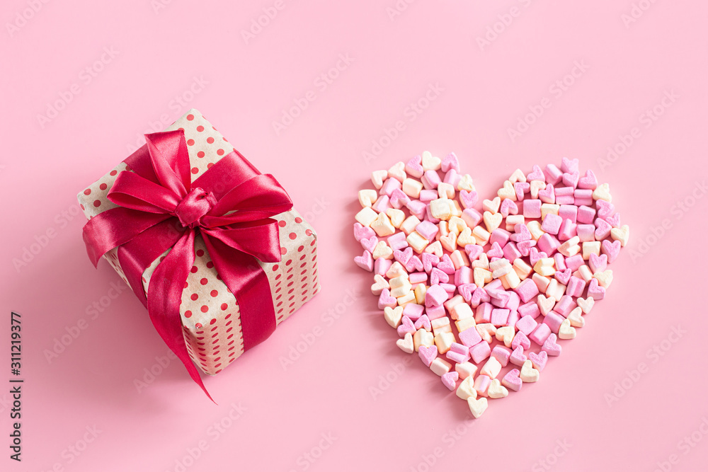 Fototapeta premium The concept of Valentine's day. Gift box with red bow on pink background.