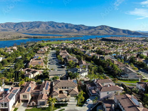 Aerial view of identical residential subdivision house with big lake and mountain on the background during sunny day in Chula Vista, California, USA. photo