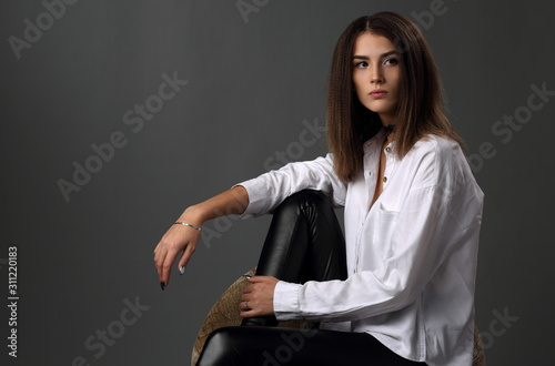 Foto Beautiful girl in white shirt and black leather pants