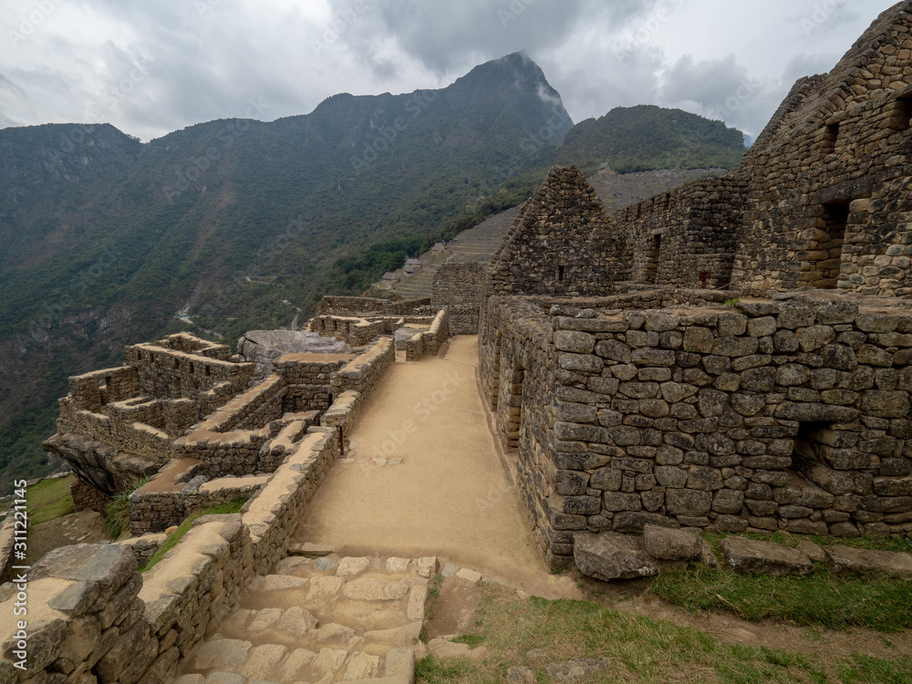 Stone walls at Machu Picchu citadel, mountain range in the background