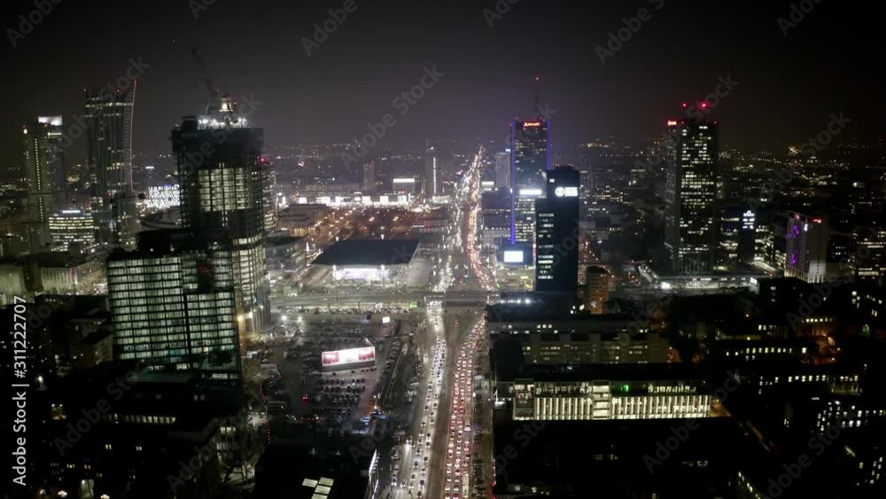 Drone shot at night cityscape with skyscrapers and buildings on a foggy night. Warsaw-Poland. 04. December. 2019. Aerial view of the night city with traffic and skyscrapers in the fog. Drone shot at night cityscape with skyscrapers and buildings on a foggy night. Warsaw-Poland. 04. December. 2019. Aerial view of the night city with traffic and skyscrapers in the fog.