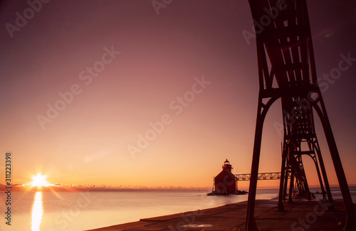 lighthouse and pier silhouette at sunrise