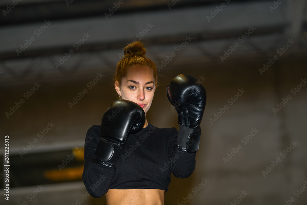 Woman smiles while wearing a pair of boxing gloves