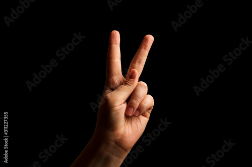 Hand Showing Sign of K Alphabet in American Sign Language (ASL), isolated on black background. Sign language © kseniaso