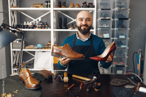 Bootmaker shows repaired shoes, footwear repair © Nomad_Soul