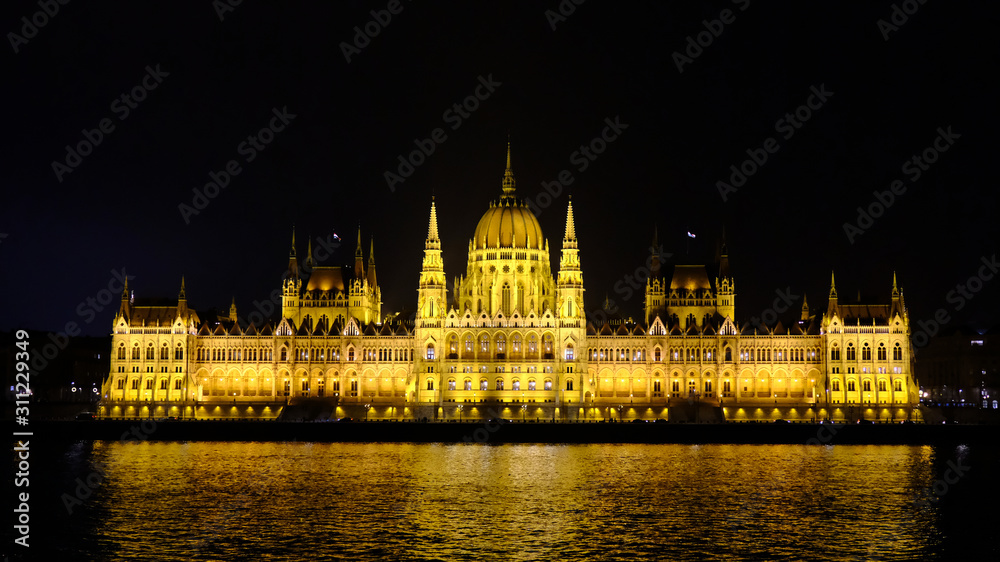 Illuminated Budapest Parliament building with reflection in Danube river at night