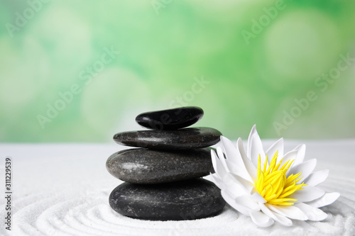 Zen garden. Beautiful lotus flower and stones on white sand