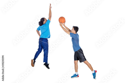 Two athletic men playing basketball together