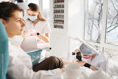 Two women on pedicure procedure in beauty salon