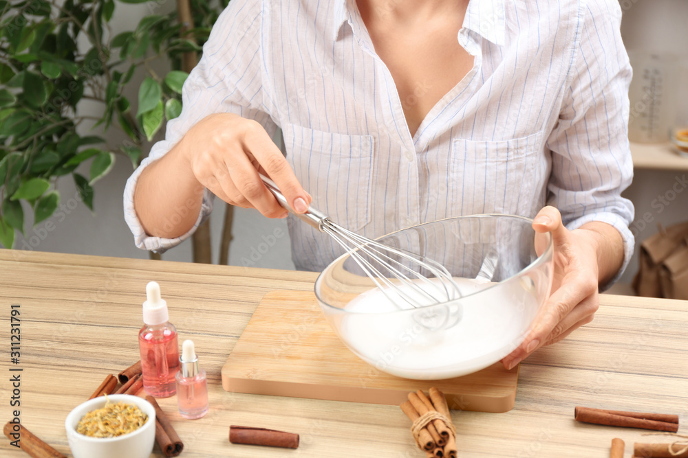 Woman making natural handmade soap at wooden table, closeup Woman making natural handmade soap at wooden table, closeup