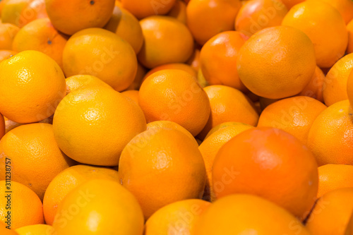 Fresh oranges in the store. Close up view of madarines orange on the sheft in the supermarket. Healty and fresh fruits background in a supermarket super store