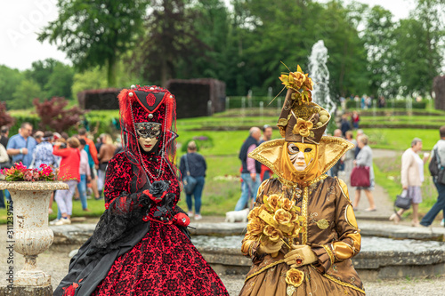 ANNEVOIE GARDENS, BELGIUM - June 9, 2019: Women standing in masks and masquerade costumes during Venetian carnival in Annevoie  gardens, Rue des jardins, 37 a, Annevoie/ Belgium
