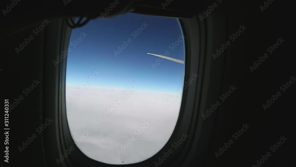 Wing of passenger airplane passenger pov through plane window during flight. Ice crystals on porthole glass of flying airplane and hot gases from the engine. Aircraft above clouds. Air travel concept. Wing of passenger airplane passenger pov through plane window during flight. Ice crystals on porthole glass of flying airplane and hot gases from the engine. Aircraft above clouds. Air travel concept.