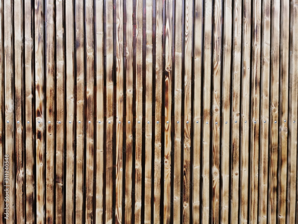 Wooden thin slats with traces of firing. Thin vertical slats.Wooden background.