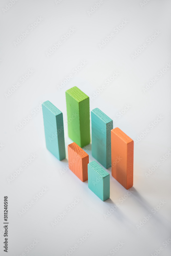 Two parallels of blue, orange and green wooden bricks forming financial charts Two parallels of blue, orange and green wooden bricks forming financial charts