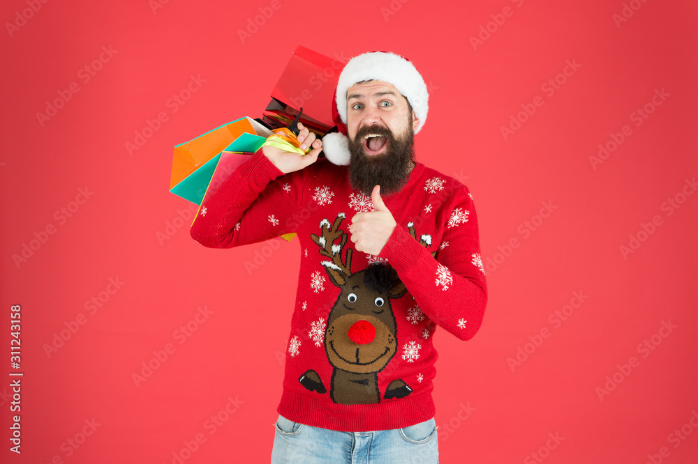 Shopping hobby. Take it all. Man on winter shopping. Guy wear knitted sweater and hat carry shopping bags. Bearded hipster customer. Consumerism concept. Wholesale and retail. Seasonal sale Shopping hobby. Take it all. Man on winter shopping. Guy wear knitted sweater and hat carry shopping bags. Bearded hipster customer. Consumerism concept. Wholesale and retail. Seasonal sale