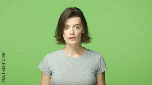 Slow-mo shocked woman in awe, open mouth astounded and wondered, gasping, holding breath startled, popping eyes camera, shopping see mush-have product, smiling in approval, green background