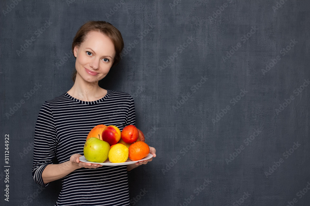 Portrait of happy girl smiling and holding plate of ripe tasty fruits Portrait of happy girl smiling and holding plate of ripe tasty fruits