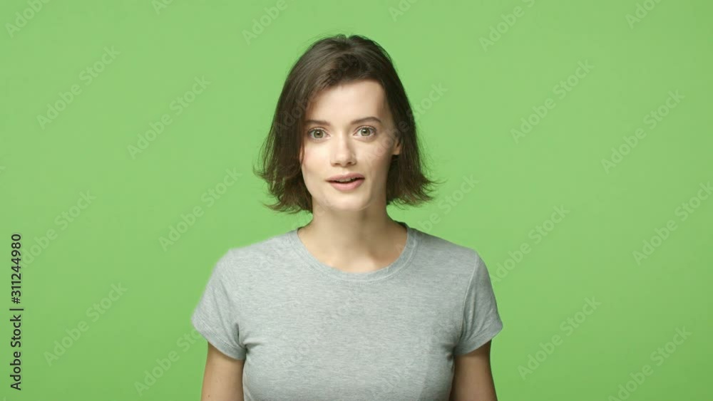 Slow-motion lucky and amazed, wondered gorgeous cute girl with short haircut, gasping, seeing breathtaking gift, smiling showing braces, touch mouth impressed and astounded, green background Slow-motion lucky and amazed, wondered gorgeous cute girl with short haircut, gasping, seeing breathtaking gift, smiling showing braces, touch mouth impressed and astounded, green background
