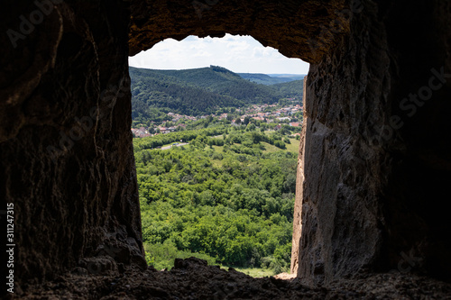 View of a valley through the stone window of a medieval fortress in europe-2