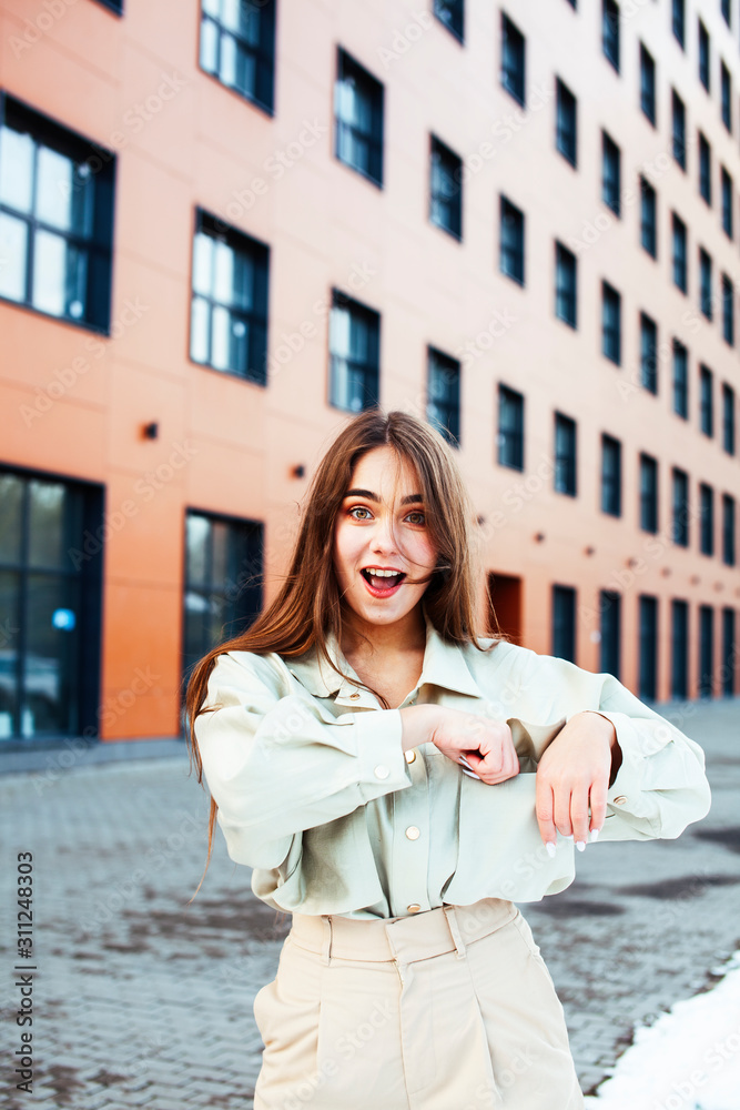young pretty teenage girl posing cheerful happy smiling wearing street style outside in europe city, lifestyle people concept