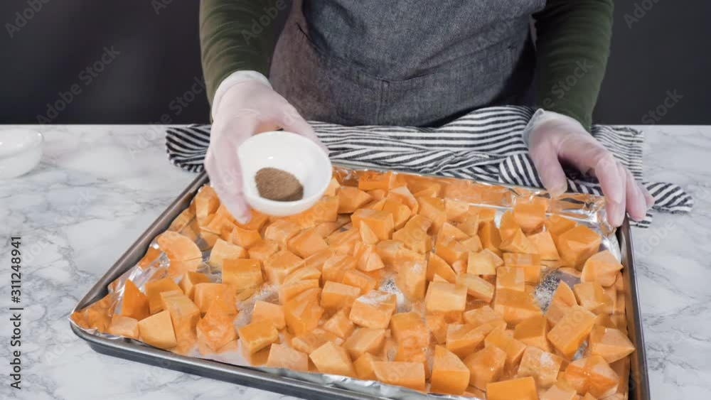 Time lapse. Seasoning butternut squash with oil, salt, and pepper for roasting in the oven.