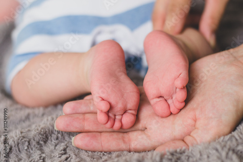 Baby feet with heels up on mother’s palms