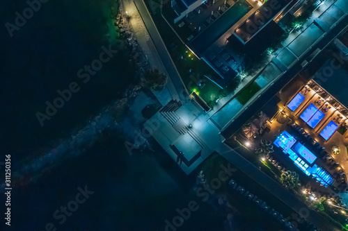 Aerial top view of Cyprus illuminated promenade at night with seaside, mediterranean tourist resort. Travel to Cyprus concept