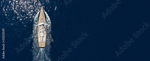 Aerial drone ultra wide photo of luxury sail boat with wooden deck cruising deep blue Aegean sea, Greece