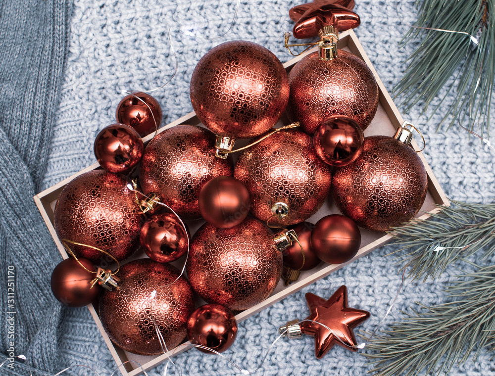 Christmas balls in a craft box on a gray background and with fir branches Christmas balls in a craft box on a gray background and with fir branches