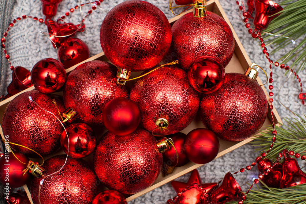 Christmas balls in a craft box on a gray background and with fir branches Christmas balls in a craft box on a gray background and with fir branches