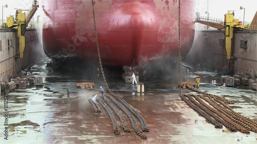 worker painting ship in the shipyard dry dock