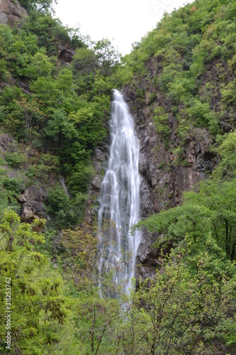 Waterfall among the greenery of the Italian Alps